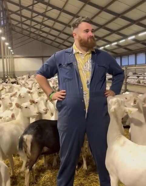 Wallace Currie stands amongst his flock in a barn